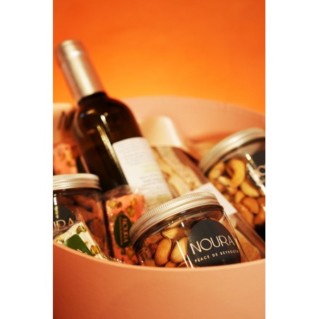 Coffret medium Noura avec vin rouge, vue de côté présentant la bouteille et les douceurs